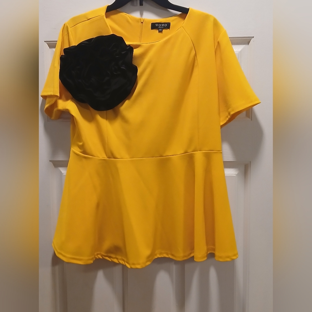 Peplum Top with a Detachable Black Fabric Flower Accent.